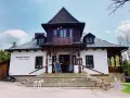 Stary Dom Zdrojowy w Beskidach, z charakterystyczną architekturą i kamiennymi schodami, zaprasza do restauracji.