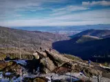 Widok na Beskidy z Wisły. Turyści na skalistym szczycie podziwiają rozległe pasma górskie i doliny.