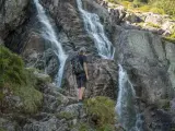 Turysta podziwia wodospad w Tatrach. Wspaniałe widoki, gdzie w Tatry warto się wybrać.