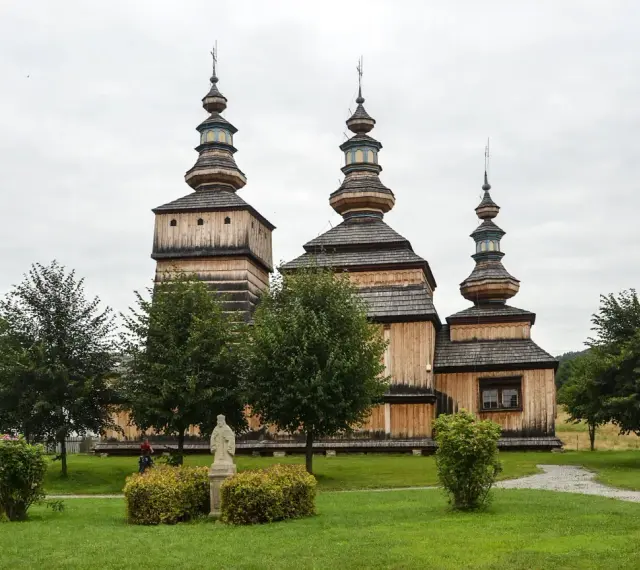 Drewniana cerkiew z trzema kopułami, otoczona zielenią. Wspaniałe krempna atrakcje dla miłośników historii i architektury.