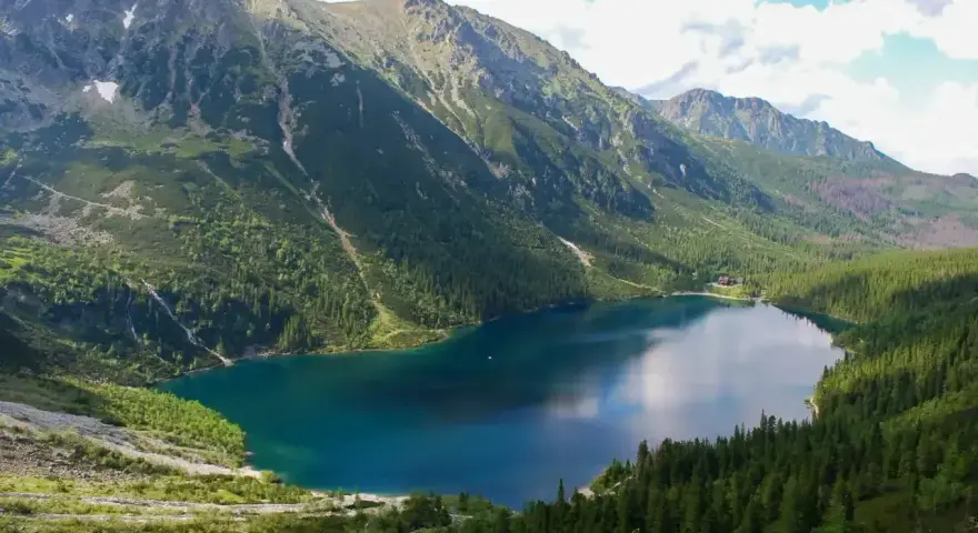 Piękne Morskie Oko w Tatrach. Czy szlak na Morskie Oko jest otwarty? Tak, widać turystów i łódki.