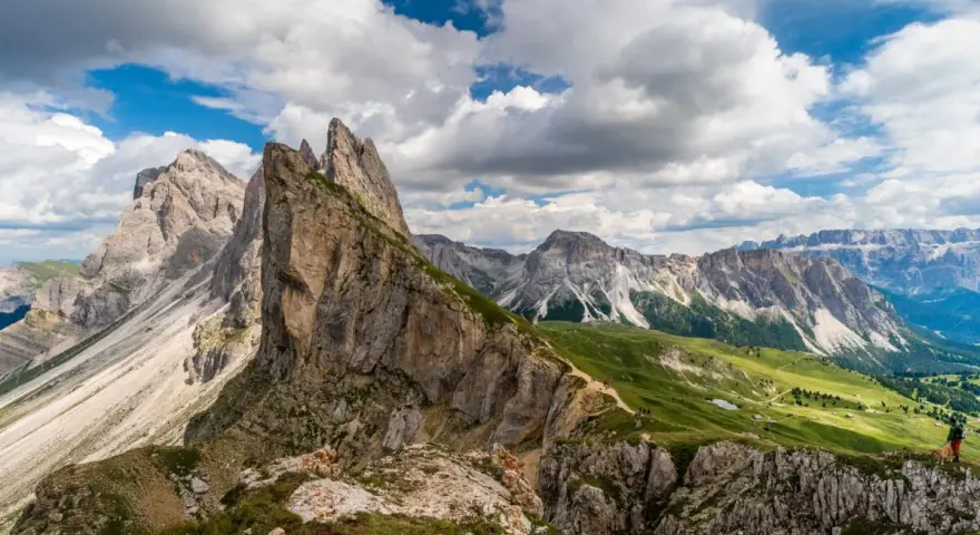 Majestatyczne szczyty Dolomitów w Val Gardena, zielone zbocza i malownicza ścieżka dla turystów.